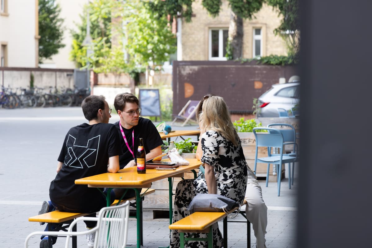 Teams collaborating during HackXplore with laptops and brainstorming notes.